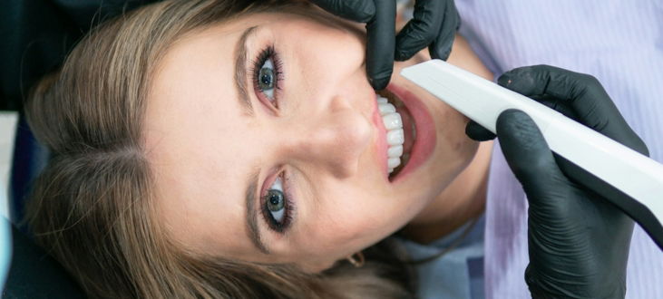 a woman is smiling while holding a toothbrush